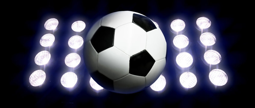 Soccer ball and spotlights at night