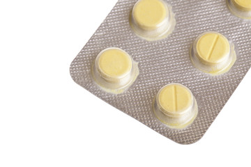 Yellow  pills in plastic blister on white