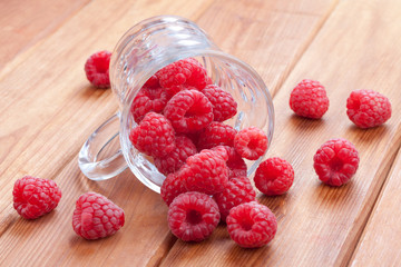 fresh raspberries spilling from a cup