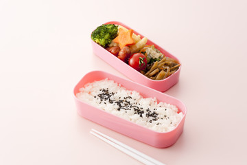 ピンクのお弁当箱とピンクの背景
