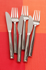 Forks and knives on a red tablecloth