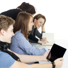 Many young students learning with touchpad and books