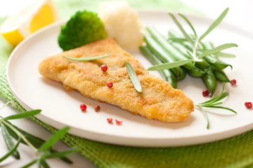 Photo sur Plexiglas Poisson Breaded fish fillet with rosemary and vegetables