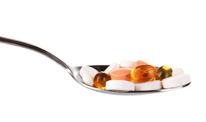 Spoon with pills isolated on white