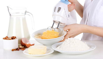Female hands mixing eggs in bowl isolated on white