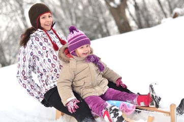 Mother and daughter sledging