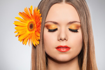 Beautiful young woman with a flower in her hair Gerbera