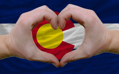 over american state flag of colorado showed heart and love gestu