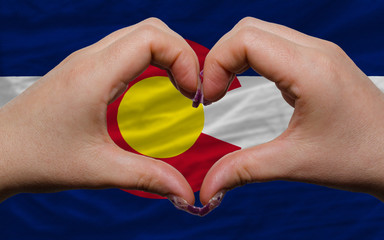over american state flag of colorado showed heart and love gestu
