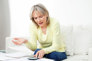 Frustrierte Seniorin vor Papierkram