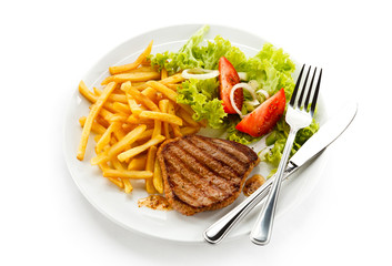 Grilled steak, French fries and vegetables