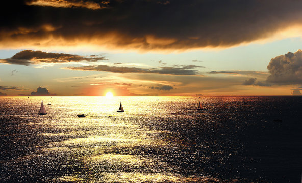 Dramatic sunset over the sea with sailing boats