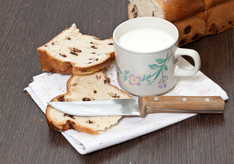Milk cup and a piece of cake on a wooden table