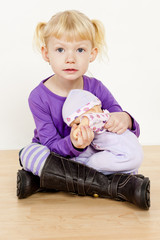 little girl playing with a doll