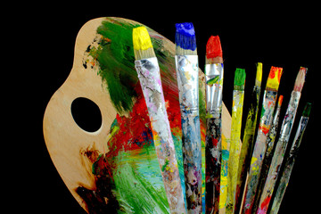 Paintbrushes and palette on black background.