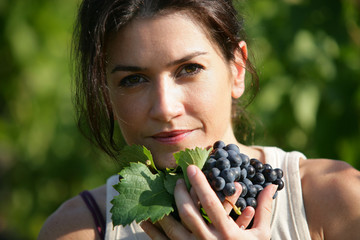 Woman holding a bunch of grapes