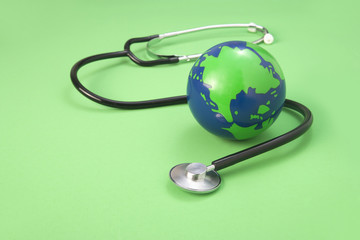 global and stethoscope on a green background