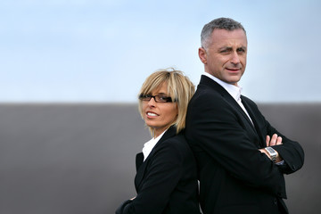 Business couple back to back on a road