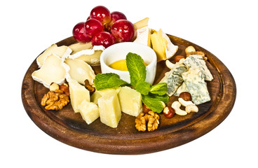 Various types of cheese with honey, nuts and grapes on plate, is