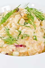 photo of delicious risotto with seafood and dill on it