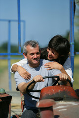 Couple riding tractor