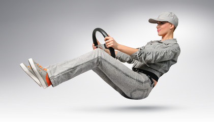 Young girl car driver in cap and jacket with a wheel