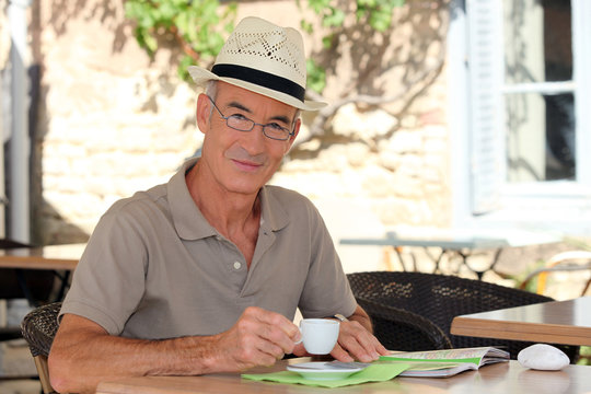 Senior Citizen Sipping His Coffee In Terrace Cafe