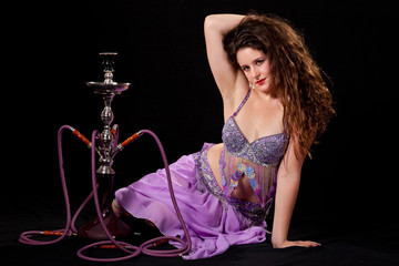Young belly dancer posing with hookah