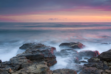 Beautiful rocky sea beach at the sunset