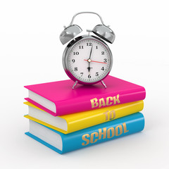 Back to school. Alarm clock on books.