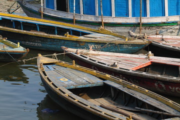 Fototapeta na wymiar Kolorowe łodzie na wodach Gangesu brązowych rzeki, Varanasi, Indie