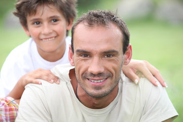 Portrait of happy man with little boy outdoors,