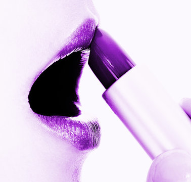 Applying Mauve Or Purple Lipstick To Her Lips