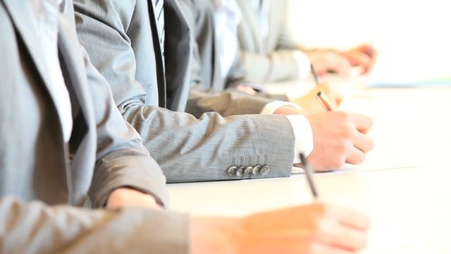 Closeup on human hands writing on paper