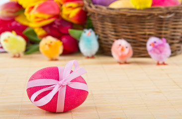 Easter egg with easter basket and flowers on background