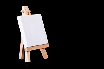 Empty canvas on easel on a black background