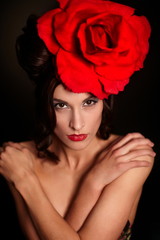 fashion woman with bright makeup lips with big red rose on head