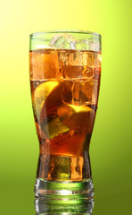 Iced tea with lemon and lime on green background