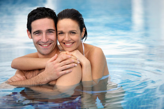 Happy couple hugging in a swimming-pool