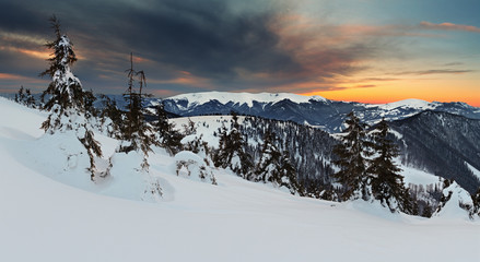 Sunset in winter mountain with dramatic sky