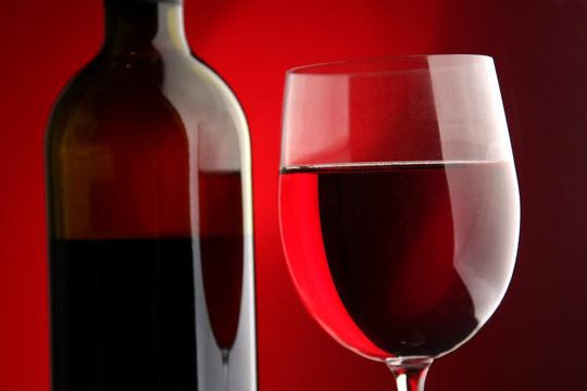 A full wineglass and a botte, closeup