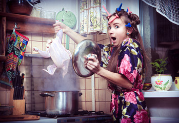 The silly housewife with carcass of a hen in hands - obrazy, fototapety, plakaty