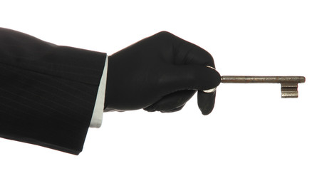 hand with black rubber glove with old rusty key