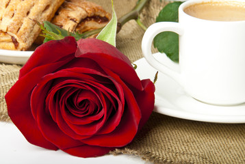 Cup of coffee and red rose