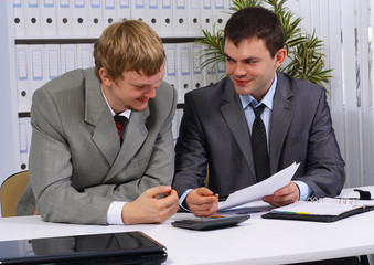 business partners over papers discussing them