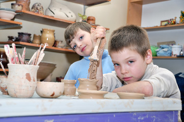 children shaping clay in pottery studio