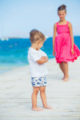 Boy with his sister walking on jetty
