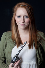 Fototapeta premium Girl holding a gun with a smirk