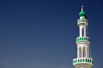 Obraz premium White mosque with minaret against blue sky (Sur, Oman)