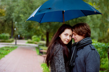 Loving couple under an umbrella in park